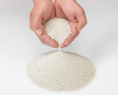 Hände halten Extover Löschgranulat – mineralisches Granulat zur sicheren Brandbekämpfung bei Lithium-Ionen-Akkus.