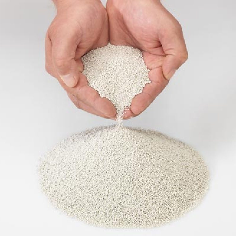 Hände halten Extover Löschgranulat – mineralisches Granulat zur sicheren Brandbekämpfung bei Lithium-Ionen-Akkus.